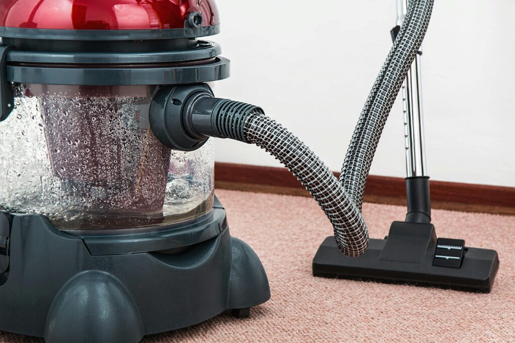 Carpet & Sofa Cleaning Close-up of a modern vacuum cleaner with water filtration on carpet floor indoors.